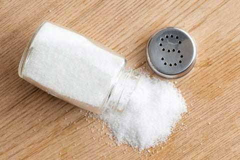 Tipped salt shaker on a wooden table