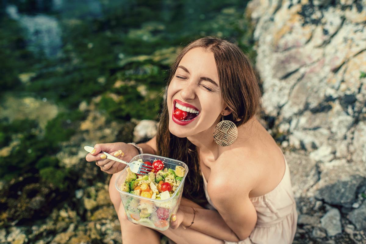 Woman eating a healthy salad outdoors