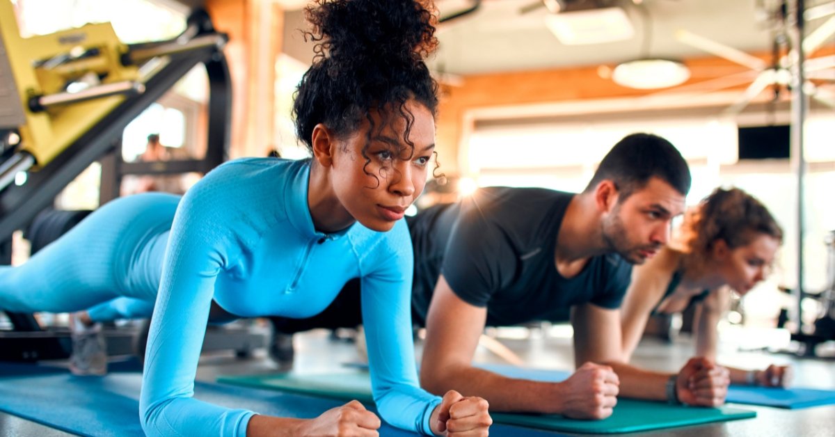 People doing forearm planks in a gym class