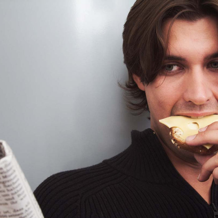 Man eating toast while reading